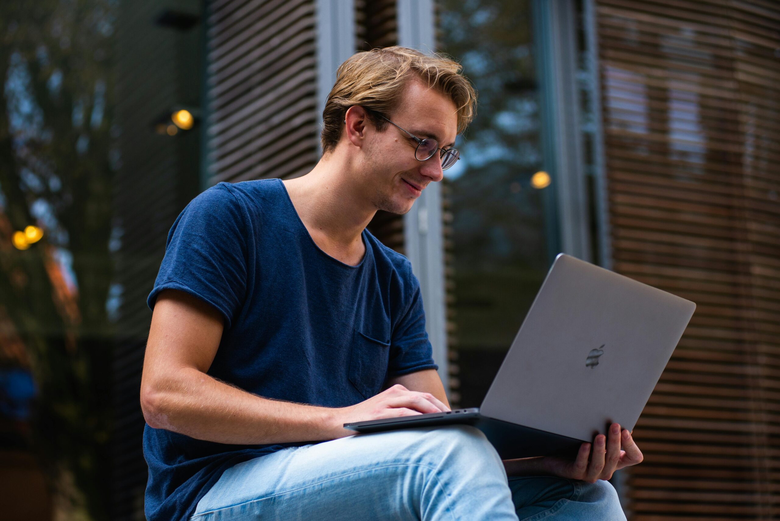 Selective Focus Photo of a male student Using Laptop