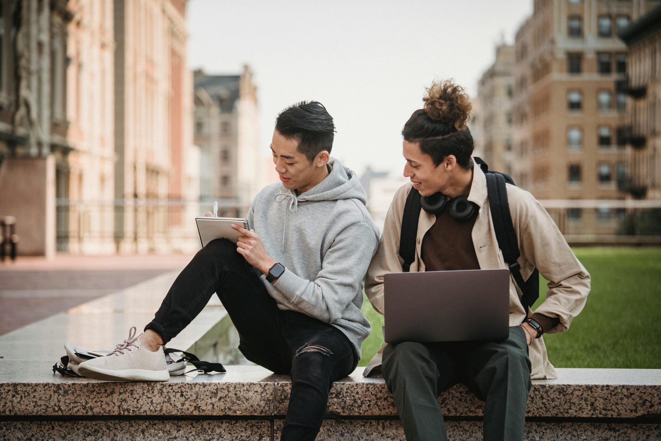 Two male students Sitting at the Park while Having Conversation