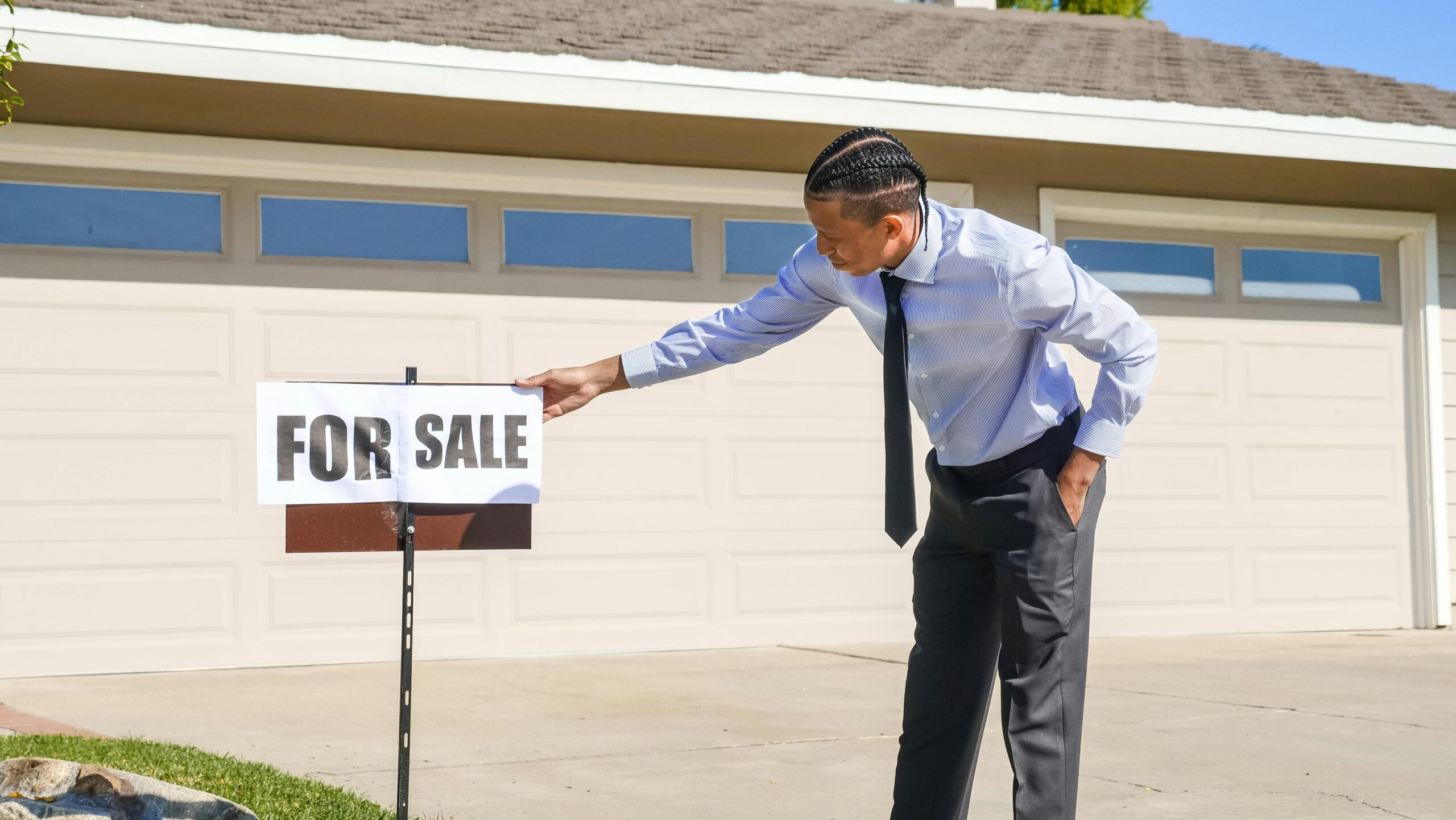 Man in a Dress Shirt Holding a House for Sale Signage