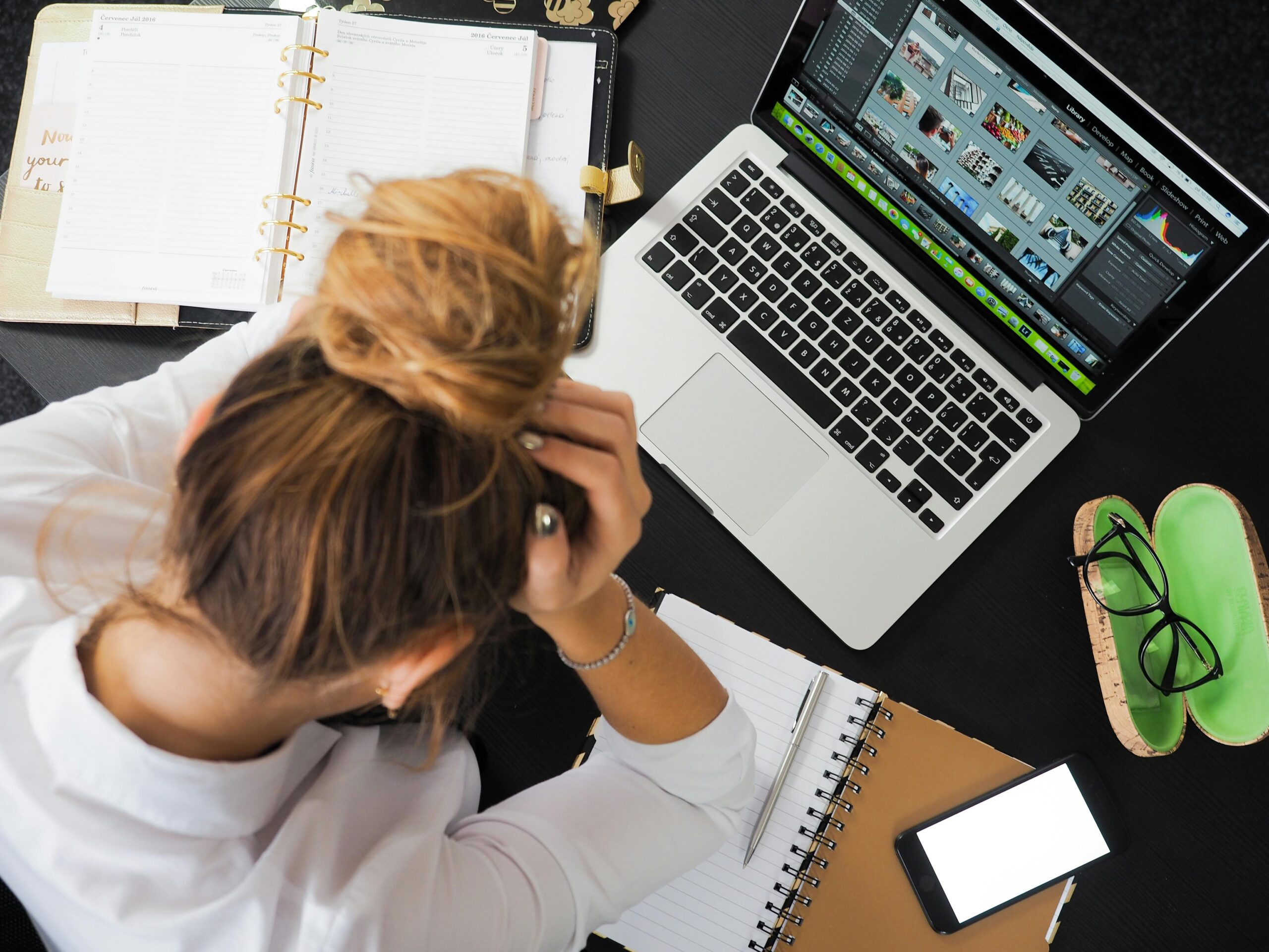 A female student sitting in front of Macbook and thinking